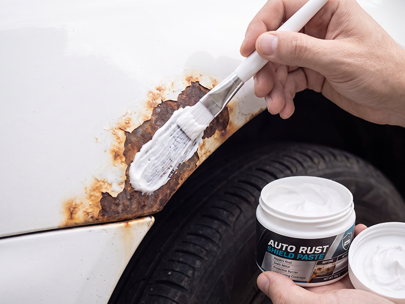 Applying rust repair paste evenly to the car panel